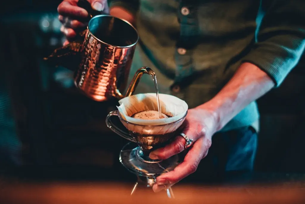 Barista gießt frischen Filterkaffee in einem Café auf