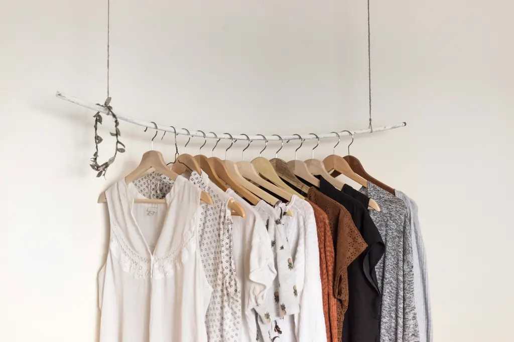 Minimalistische Kleiderstange mit Blusen und Hemden