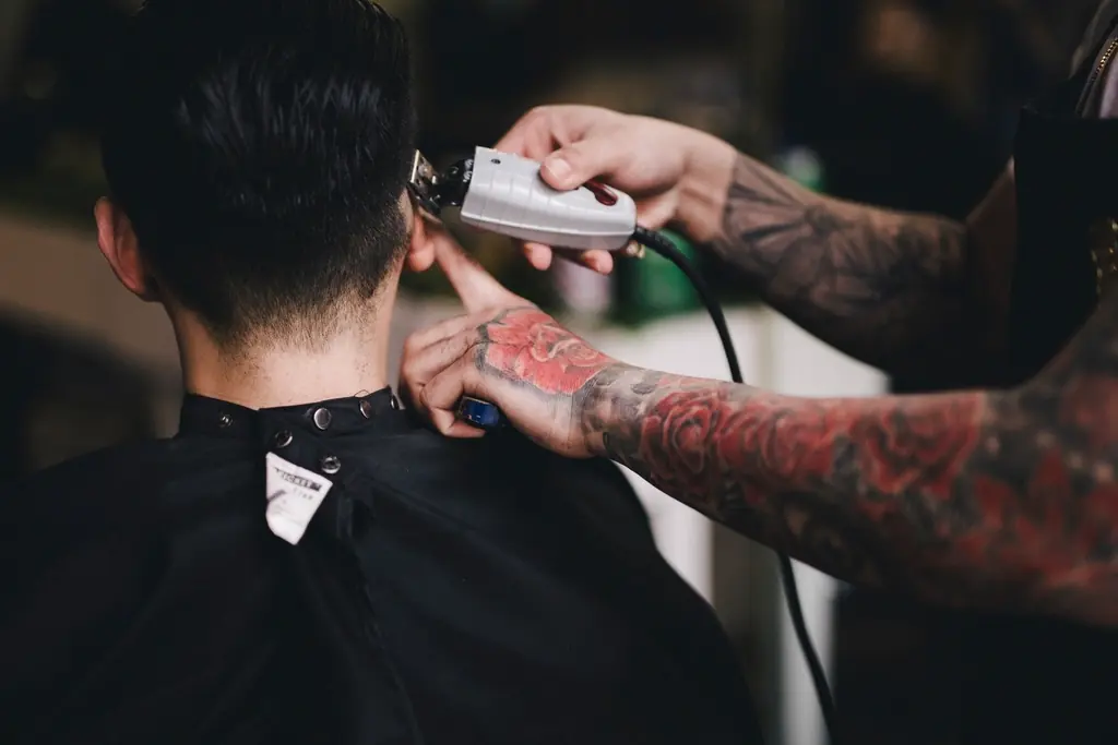 Barber schneidet einem Kunden mit der Haarschneidemaschine die Haare